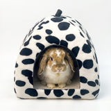 Load image into Gallery viewer, Cute lop bunny nestled in a black and white cow print plush hideaway bed for small rabbits up to 3.3 lbs.