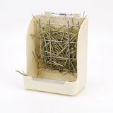 Load image into Gallery viewer, A cream colored rabbit hay feeder featuring a metal grid dispenser and a built-in tray to contain hay and reduce mess, standing against a white background. A simple and effective solution for a clean bunny enclosure
