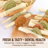 Load image into Gallery viewer, Fresh compressed grass cakes and sweet bamboo chews placed on a wooden board for small pet dental grinding