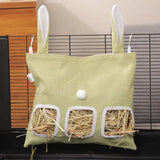 Load image into Gallery viewer, A medium-sized mint green bunny ear grass pellet dispenser bag featuring three windows filled with grass pellets, hanging securely in a modern wire pet cage.