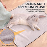 Load image into Gallery viewer, Fluffy lop rabbit relaxing and flopping flat on the unfolded ultra-soft plush fleece grooming wrap used as a sleeping mat